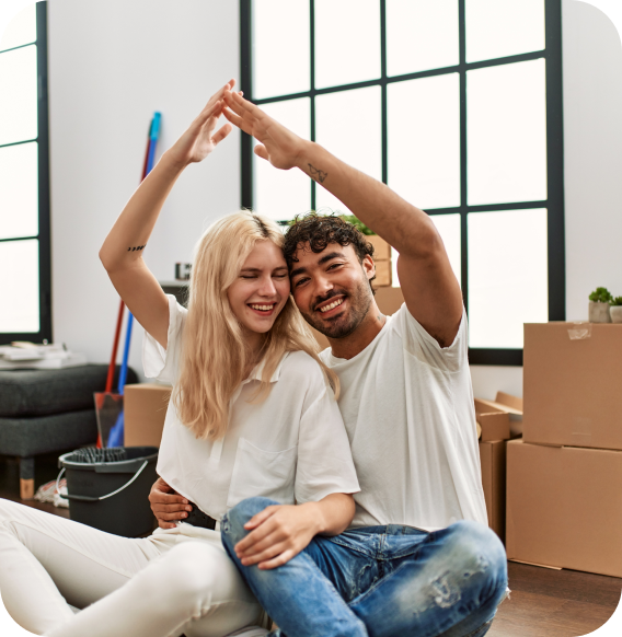 Excited couple in new Homage AI home, with moving boxes in the background