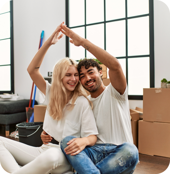 Excited couple in new Homage AI home, with moving boxes in the background